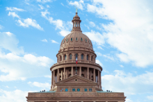 A picture of the Capitol building in Austin, Texas. The camera is angled up to see it from below. Blue sky and clouds are behind the building.